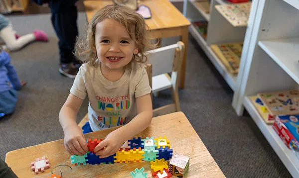 girl completing puzzle at preschool