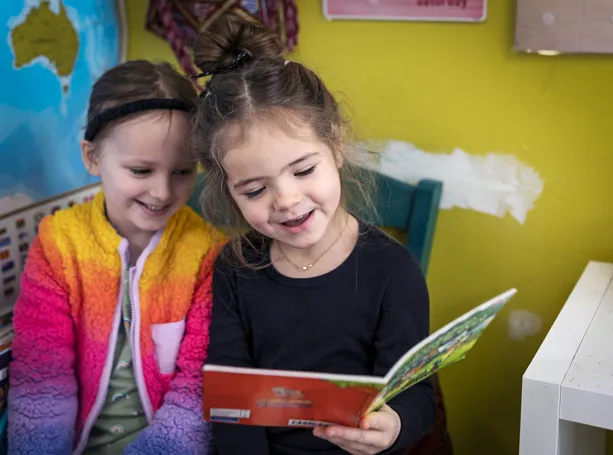 girls reading aloud to each other at preschool